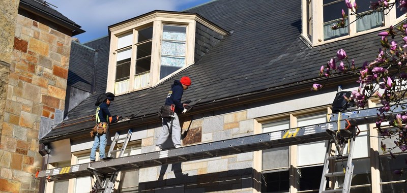 Workers from GF Sprague inspecting a roof to see is shingles need to be replaced.