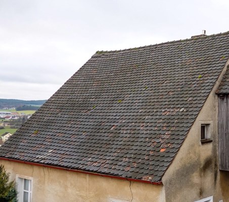 Slate roof with signs of discoloration, leaks, broken shingles, and more.